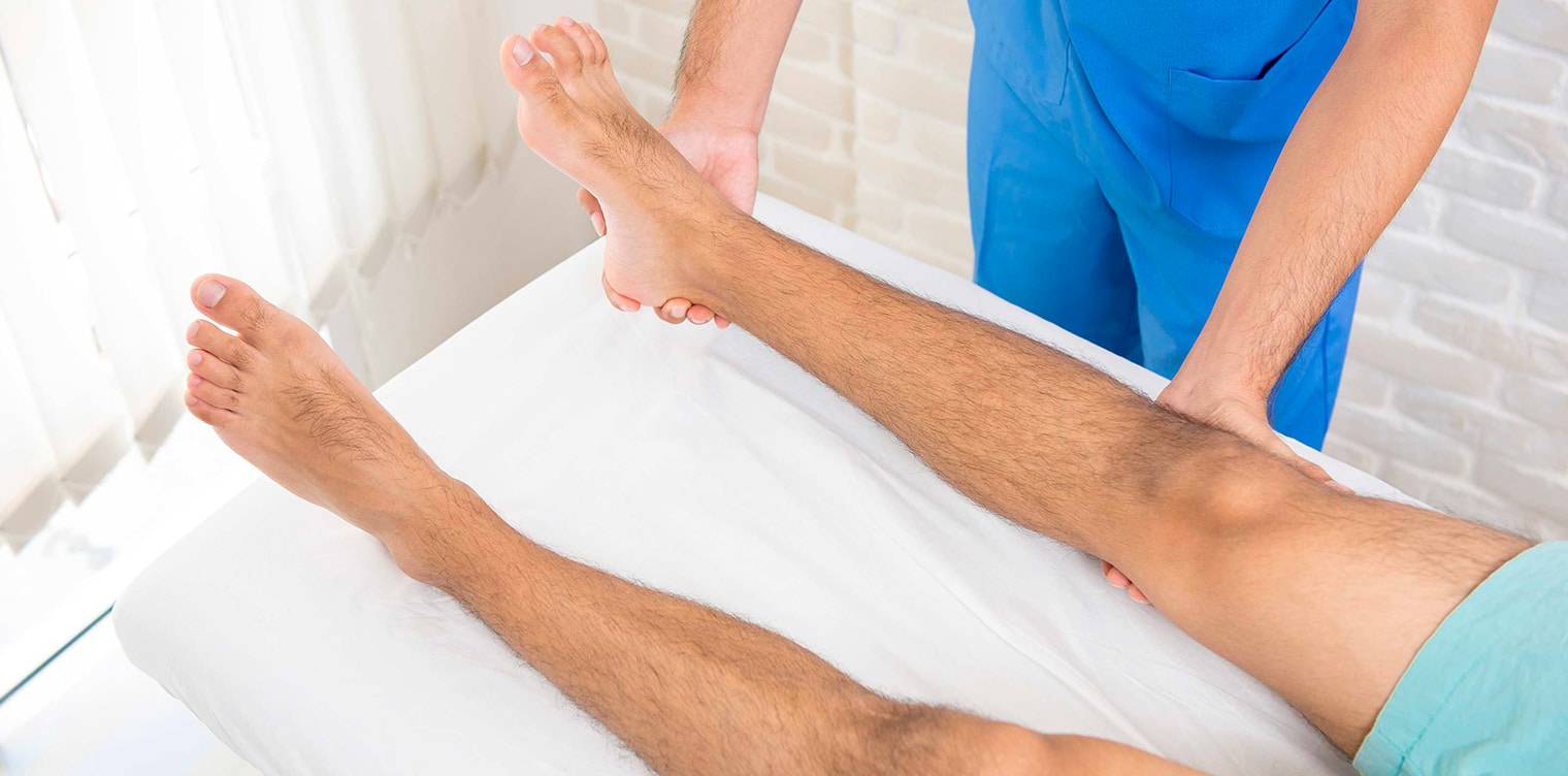 Kinesitherapeute examinant les jambes d un homme - fracture plateaux tibiaux | IK Paris