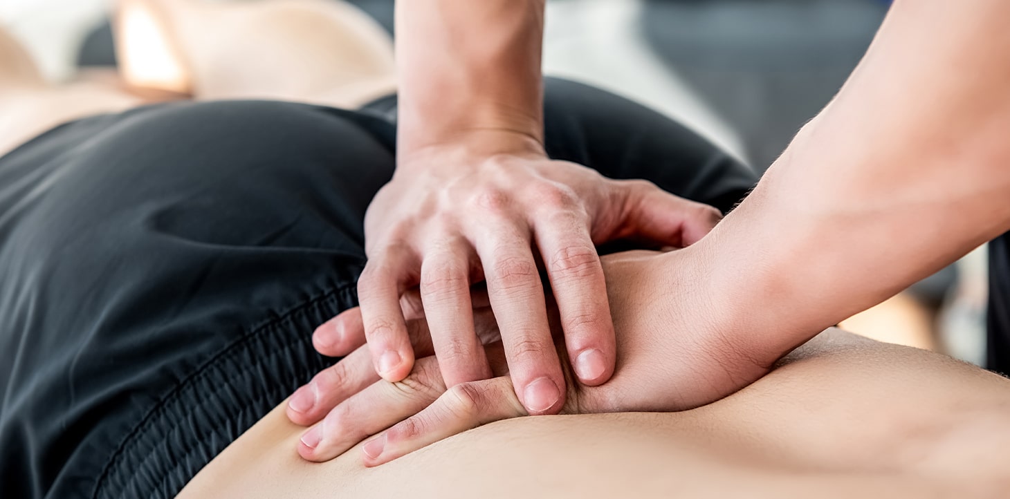 Dos d un homme se faisant un massage par un professionnel fracture de sacrum | IK Paris