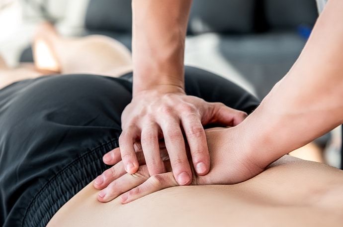 Dos d un homme se faisant un massage par un professionnel fracture de sacrum | IK Paris