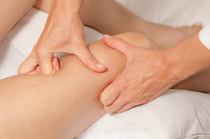 Kinesitherapeute faisant des massage sur le genou d une femme - syndrome myofascial IK Paris